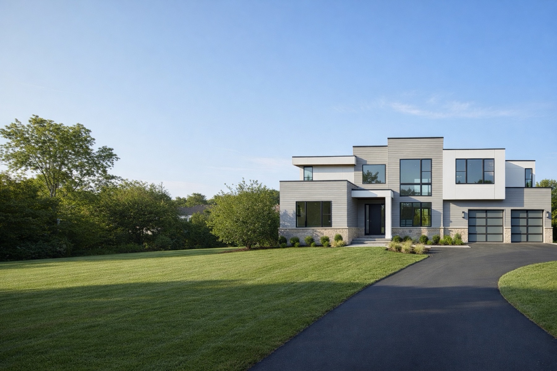 Arkline Development custom home — modern two-story luxury build with stone foundation, large windows, and frosted-glass garage doors.